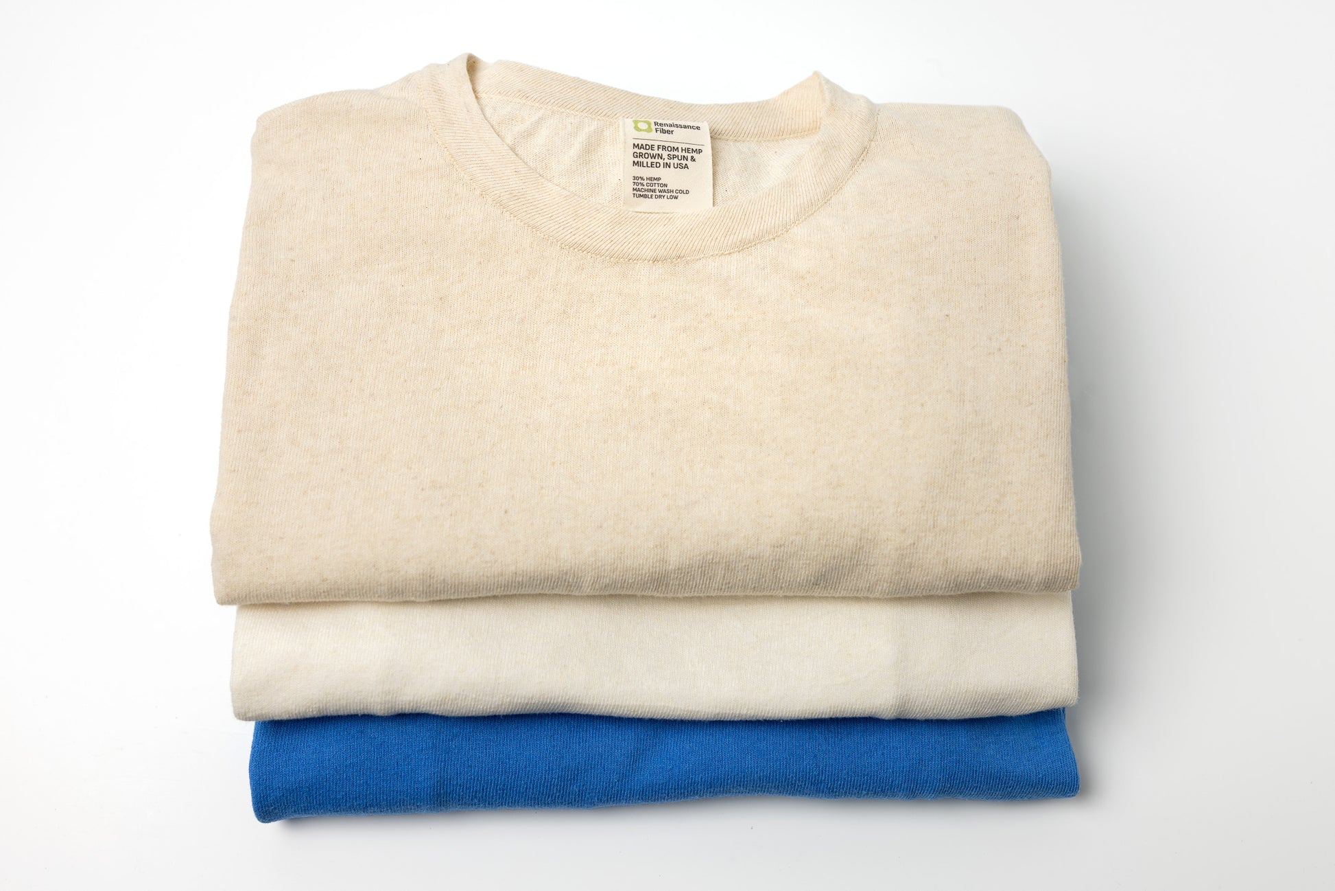 Folded beige and blue shirts on a white background
